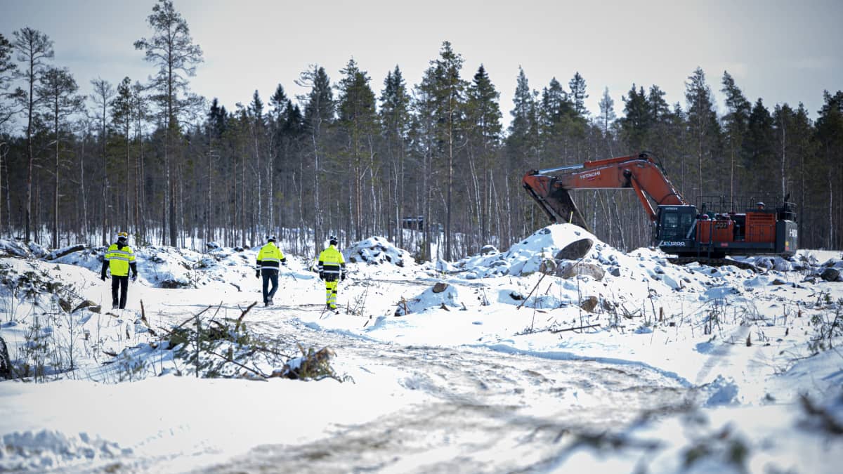 Kolme miestä kävelee Keliberin kaivostyömaalla. 