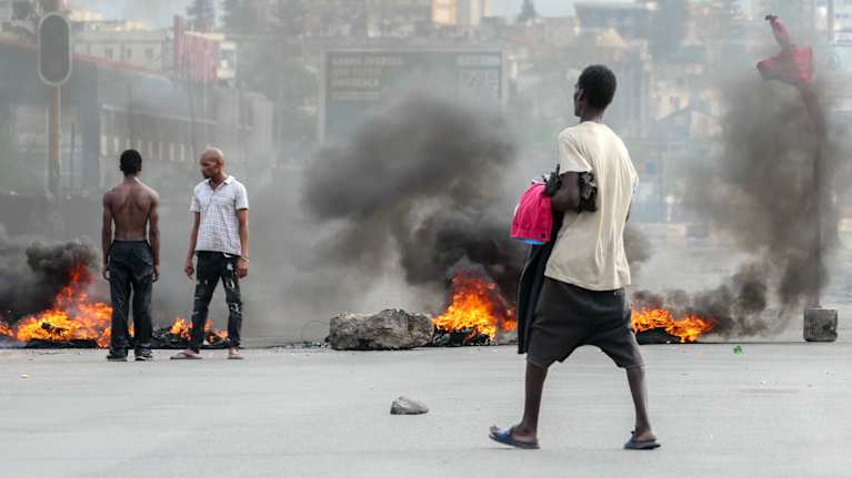 Kadulla palaa roskia mielenosoituksessa Mosambikin pääkaupungissa Maputossa.