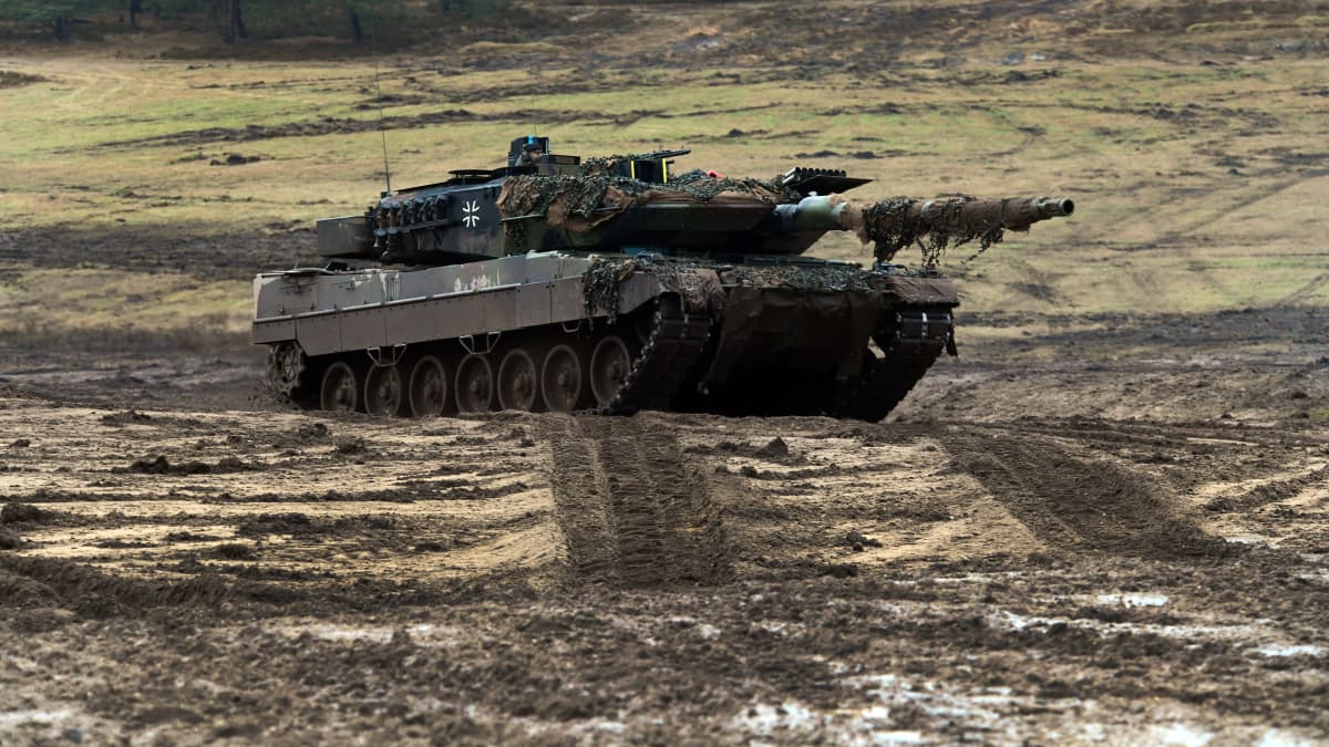 Saksan tunnuksin maalattu Leopard 2 -panssarivaunu mutaisella pellolla.