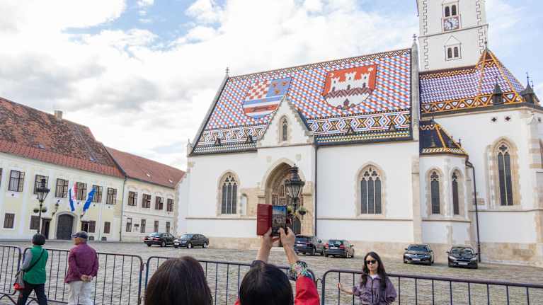 Turistit kuvaavat Zagrebin keskustassa Pyhän Markuksen kirkon edessä