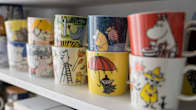 Moomin mugs displayed on a shelf.