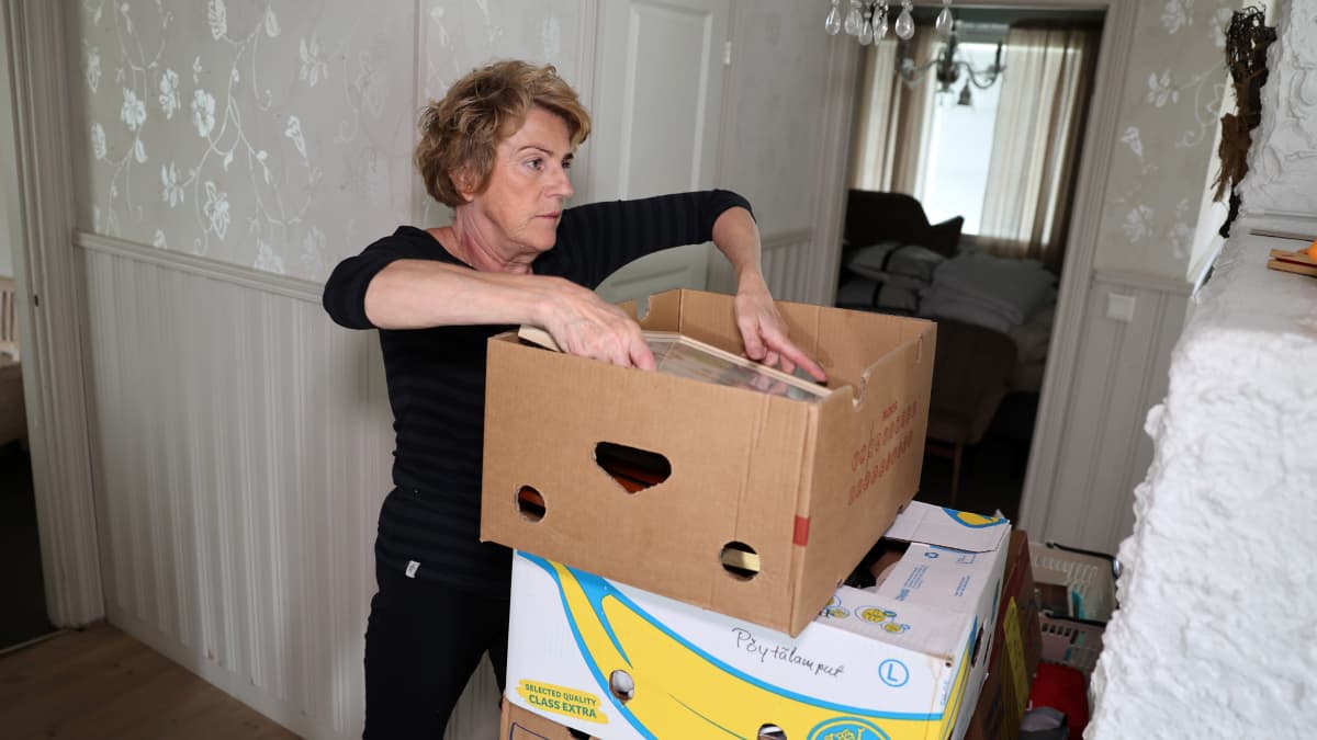 Heini Barsk kotonaan pakkaamassa tavaroita laatikoihin muuttoa varten. 