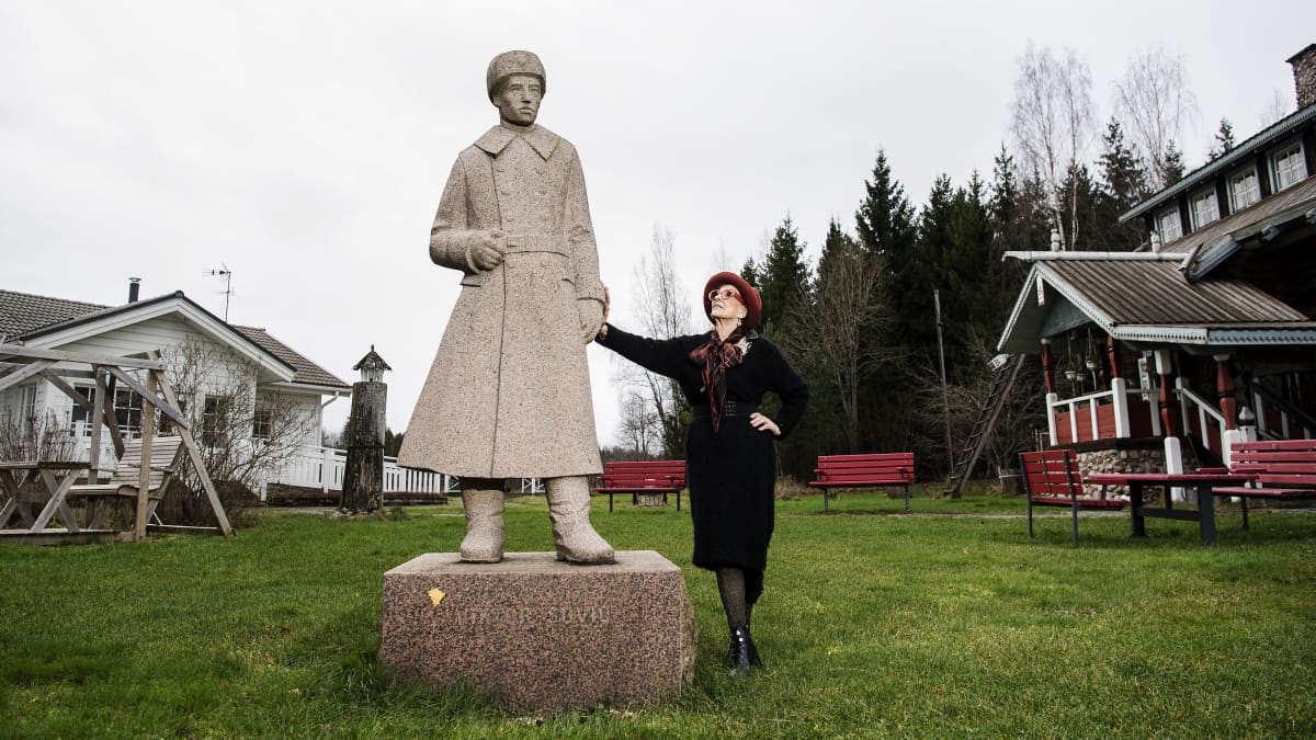 Aira Samulin poseeraa isänsa patsaan kanssa marraskuussa 2020.