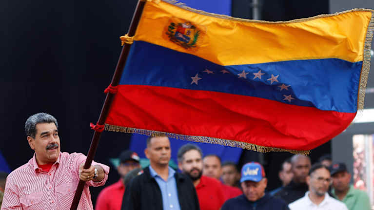 Venezuela's President Nicolas Maduro waves a Venezuelan flag during a demonstration.