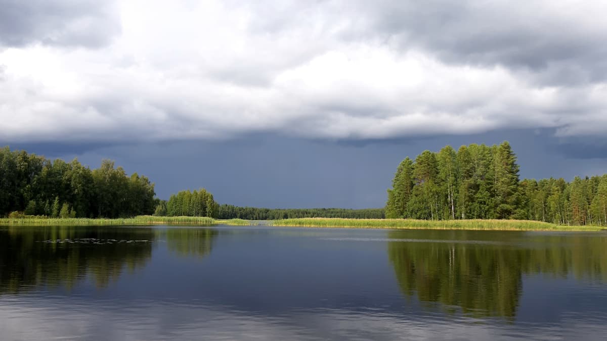 Kuvassa näkyy järvi ja tumma sadepilvi.