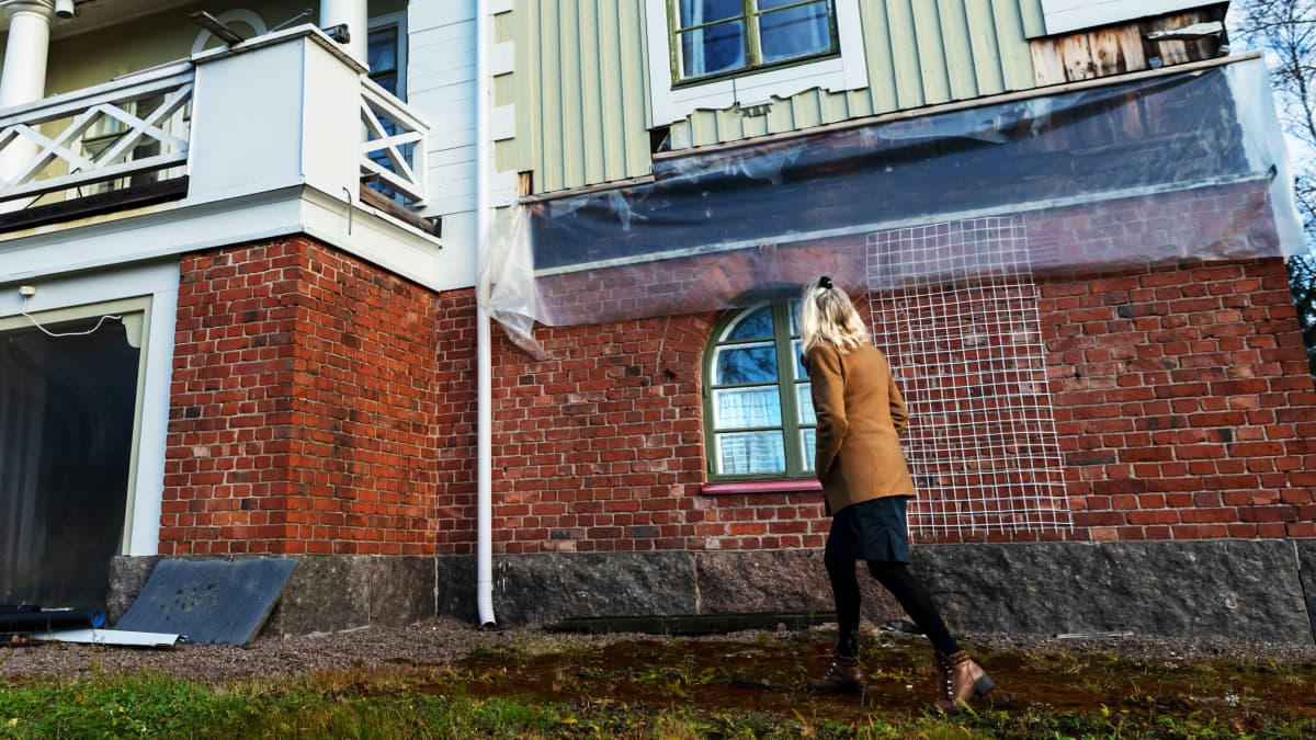 Terttu Aalto kävelee Villa Idan pihalla, katsoo huvilaa kohti.