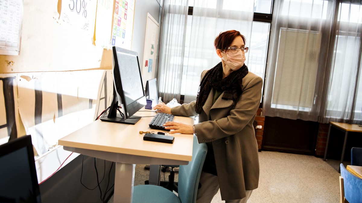 "Tässä työssä tulee istuttua muutenkin ihan tarpeeksi", sanoo Outi Vilkuna sähkötyöpöydän ääressä.