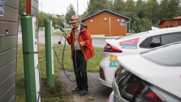 Iin kunnanjohtaja Ari Alatossava poistamassa sähköautoa latauksesta.