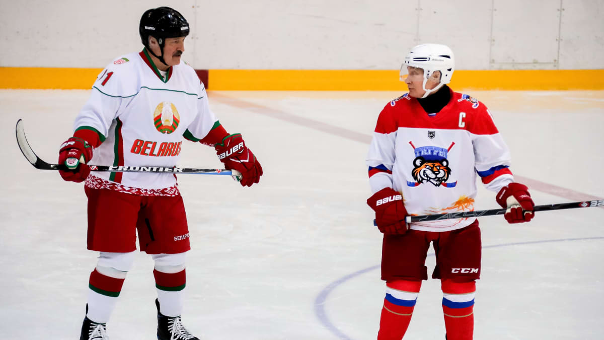 Lukašenka ja Putin ovat jääkiekkokaukalossa jääkiekkoilijan varusteissa.