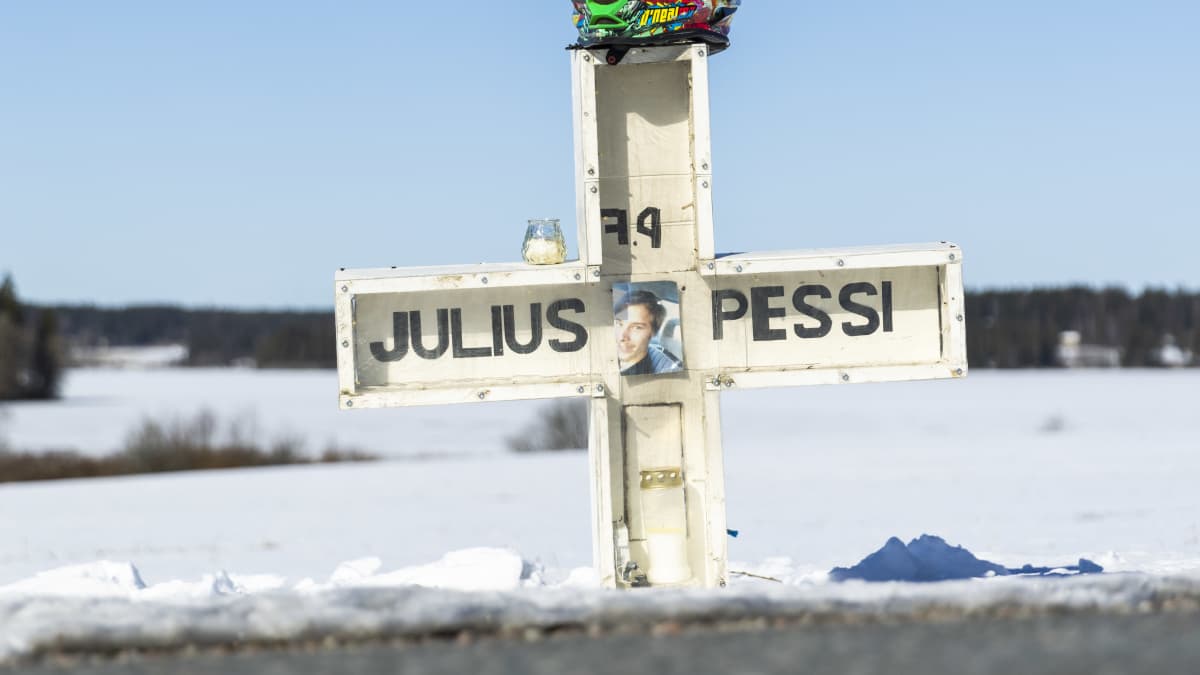 Julius Pessin kuolemaan johtanut kolaripaikka Mallusjoentiellä. Kuvassa muistoristi ja moottoripyöräkypärä.