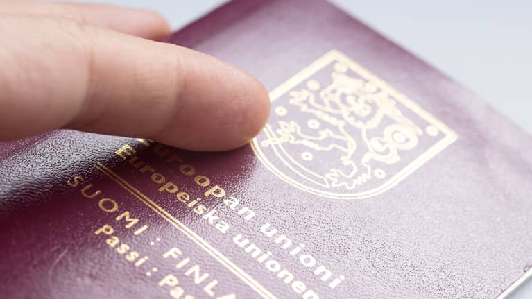 En person håller i ett finskt pass. 