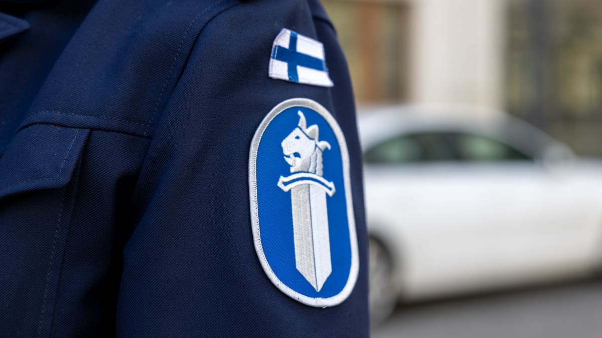 Poliisin virkapuvun tunnus ja Suomen lippu hihassa