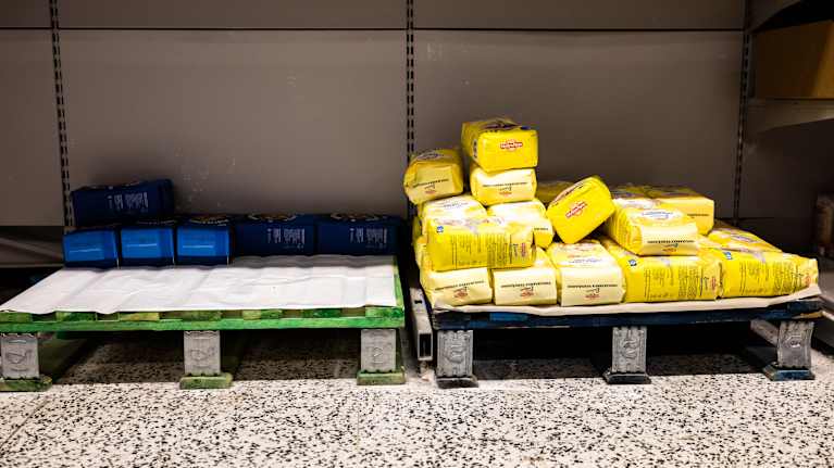 Nästan tomma lavor med några påsar mjöl i en butik.