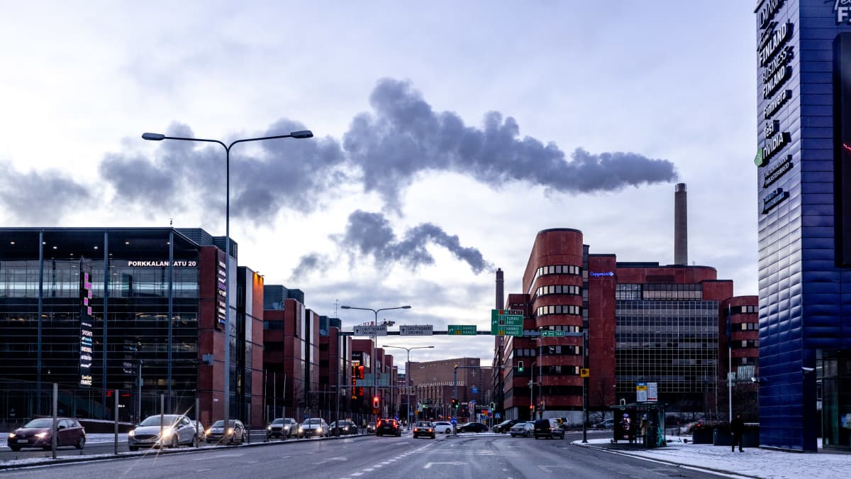 Lämpövoimalaitoksen savua taivaalla ja autoja liikenteessä.