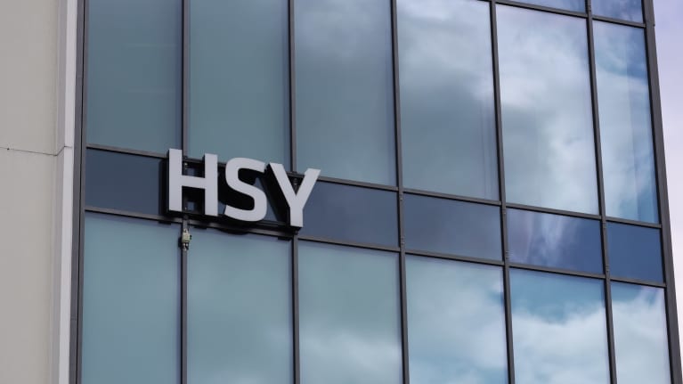 Skylt av HSY, logo på en glasväg av ett stort hus. 