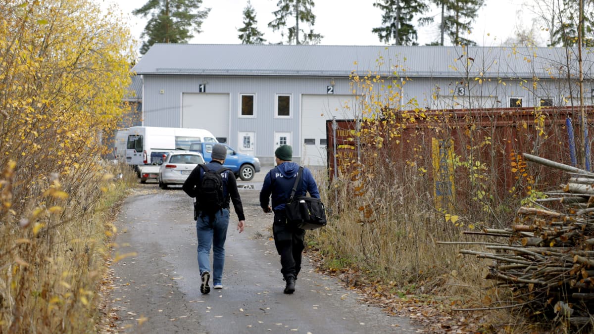 Två poliser går mot en industrihall i Rajalinna industriområde.