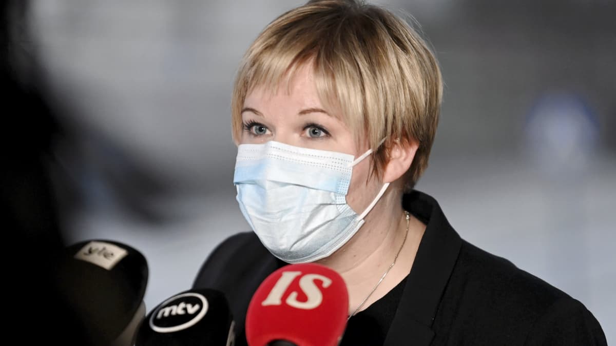 Kulturminister Annika Saarikko (C) talar i mikrofon med munskydd på.