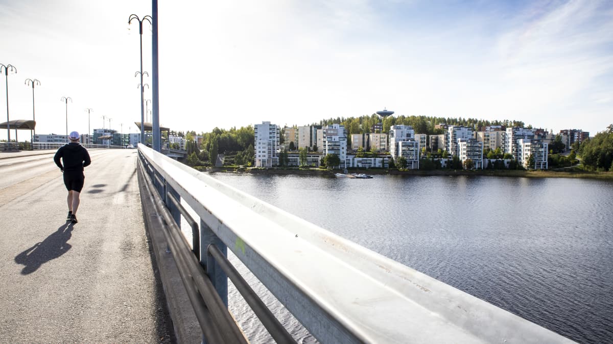 Juoksija Kuokkalan sillalla ja oikealla puolella Kuokkalan kerrostaloja Jyväsjärven rannalla.