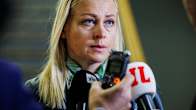 Foreign Minister Elina Valtonen speaking in front of microphones held by press.