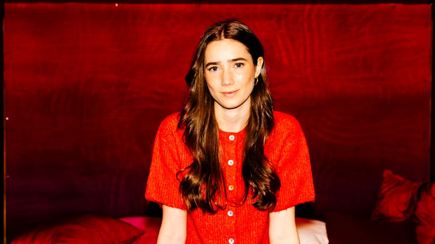 Henkilö pukeutuneena punaiseen neuleeseen.