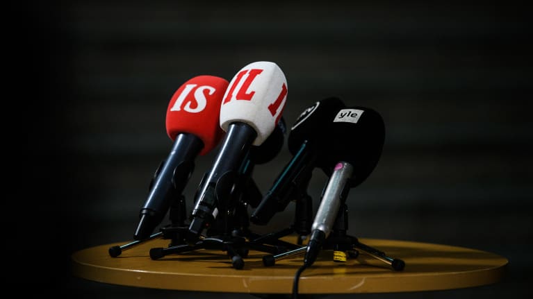 Eri mediatalojen mikrofoneja pöydällä.