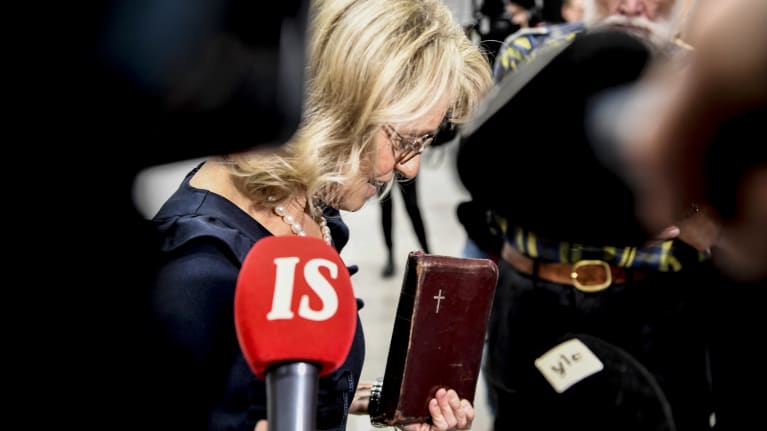 Päivi Räsänen käräjäoikeuden aulassa Raamattu kädessään.