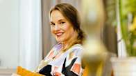 Laura Blomqvist istuu sohvalla ja katsoo kameraan.