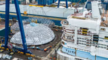 Jättimäinen lasi- ja teräsrakennelma, Dome-nimen saanut kupu Meyer Turun telakalla Icon of the Seas -aluksen vierellä.