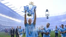 Erling Haaland Valioliigan mestaruuspokaali käsissään. Hänen päälleen kuohuvaa suihkuttaa joukkuekaveri Kyle Walker (oik.).