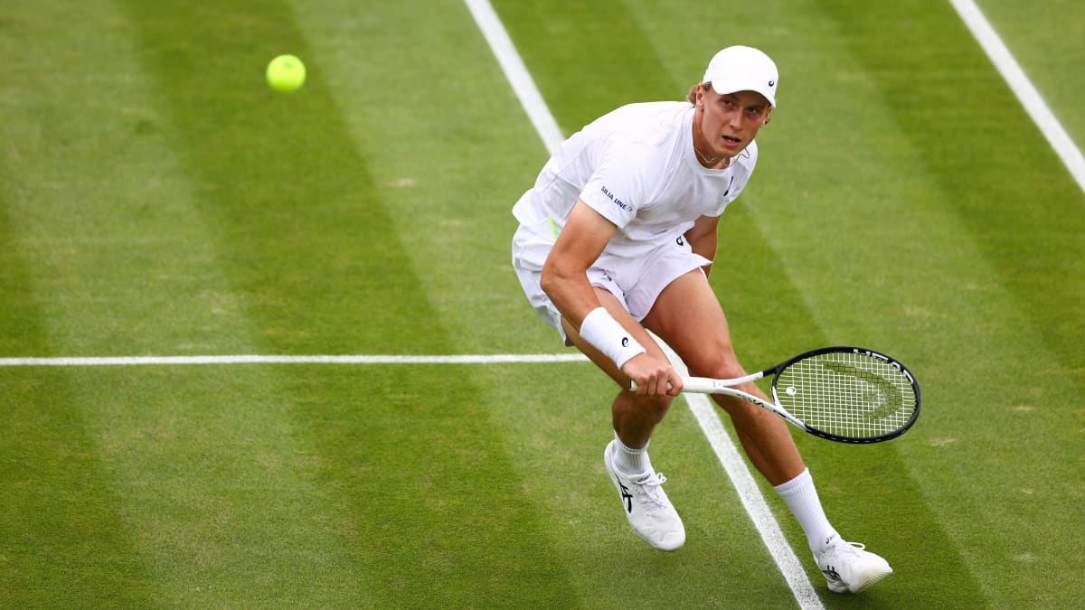 Emil Ruusuvuori palauttaa pallon Wimbledonin tenniskentällä.
