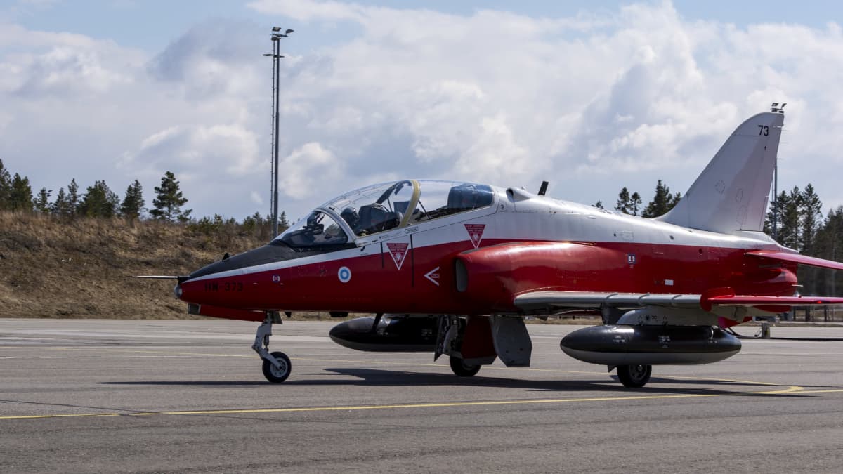 Punavalkoinen Suomen ilmavoimien tunnuksella varustettu Hawk suihkuhävittäjä rullaa lentokentällä.