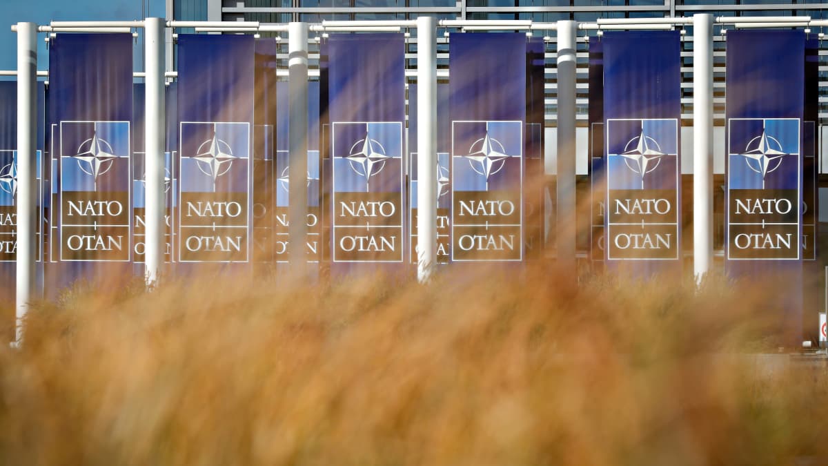 Naton päämaja Brysselissä kuvattuna syksyisen pellon takaa.