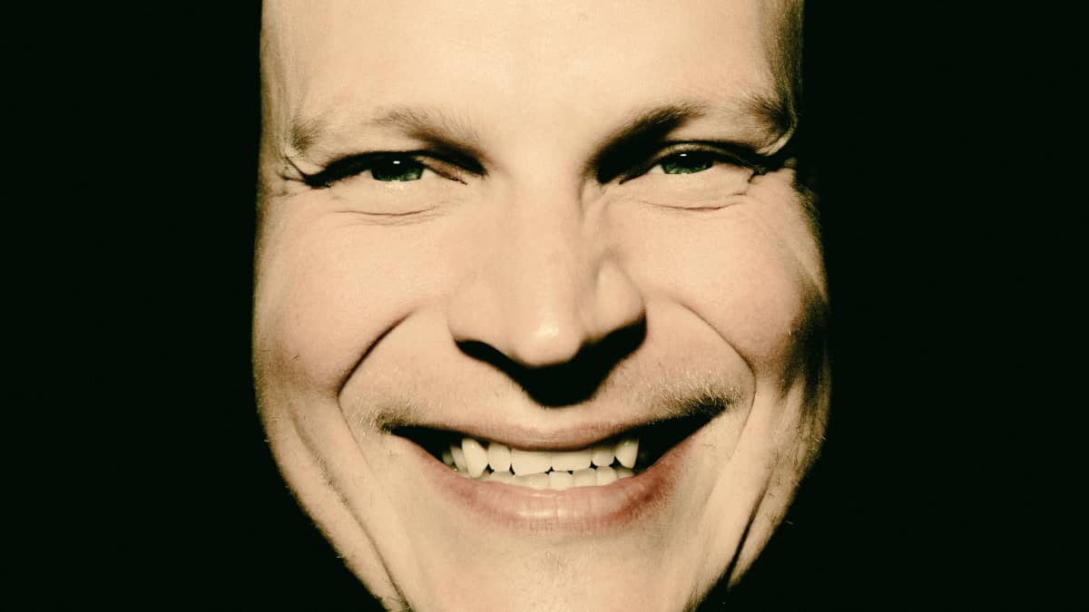 Riku Nieminen on vetänyt paidan osittain päänsä yli ja hymyilee.