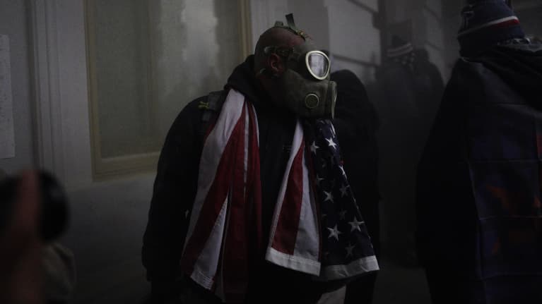 Kaasunaamarilla varustautunut tuntematon mies USA:n kongressirakennuksessa 6. tammikuuta 2021. 