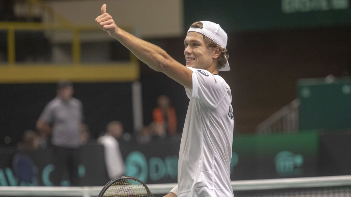 Otto Virtanen näyttää peukkua tennismaila toisessa kädessään.