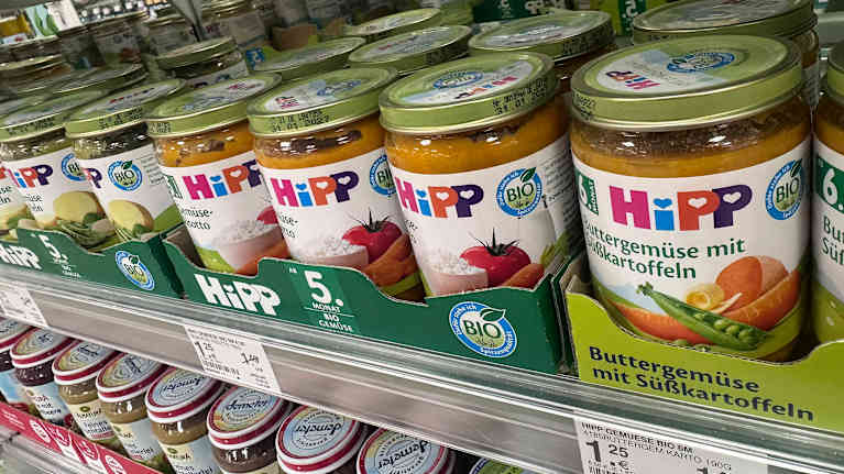Baby food jars on a grocery store shelf.