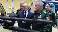Putin ja sotilaspukuiset kenraalit tarkastelevat asejärjestelmää esittelytilassa.