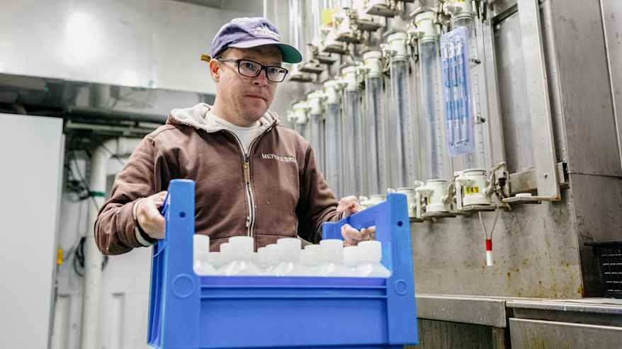 Työntekijä kuljettaa vesinäytteitä.