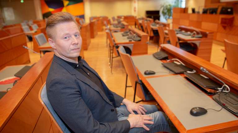 Mikki Kauste omalla työpisteellään Espoon valtuustosalissa.
