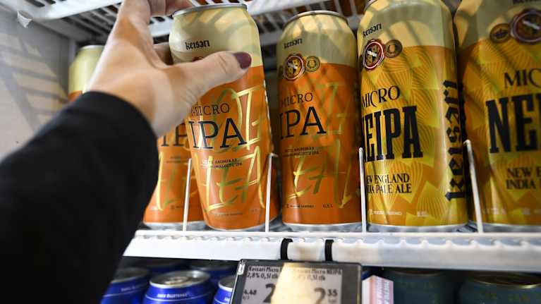 Käsi kurottaa hyllyltä Micro IPA -olutta.