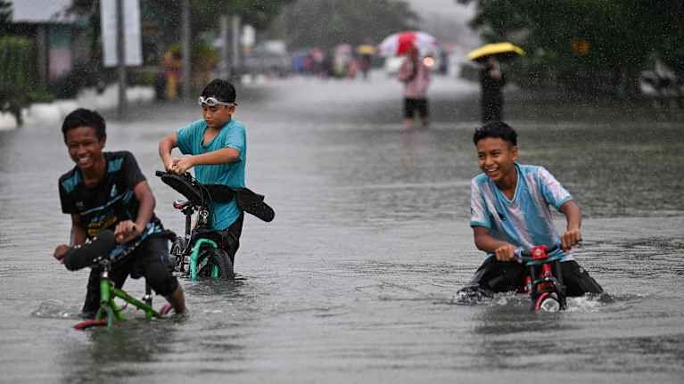 Heavy rain brought floodwaters to a street in Malaysia in November. Photo: Mohd Rasfan / AFP