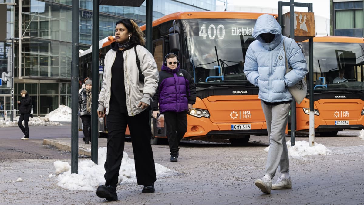 Ihmisiä HSL:n bussin numero 400 edessä bussipysäkillä.