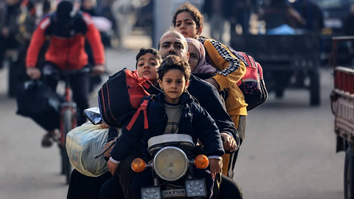 En palestinsk familj reser med motorcykel mot säkrare områden efter att Israel återupptagit attackerna mot Rafah i södra Gaza den 1 december 2023.