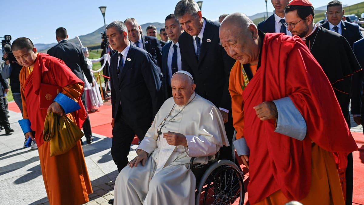 Kaksi buddhalaismunkkia ja paavi. Taustalla pukuihin pukeutuneita ihmisiä.