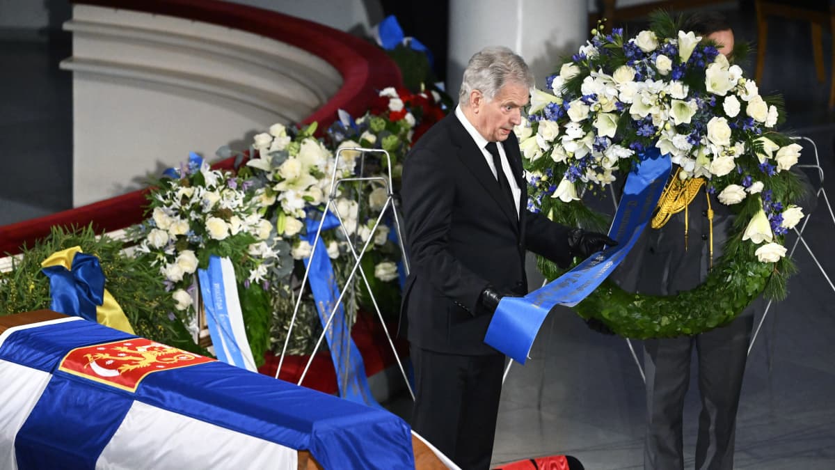 Tasavallan presidentti Sauli Niinistö laskee kukkalaitteen arkulle.