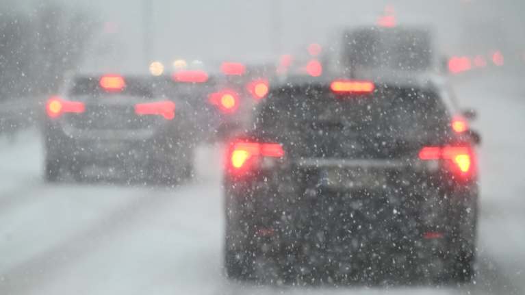 Autoja moottoritiellä lumimyrskyssä.