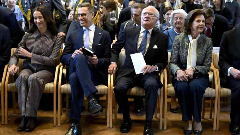 Suzanne Innes-Stubb, President Alexander Stubb, King Gustav II and Queen Silvia are seated in a row in the ballroom of the University of Gothenburg.