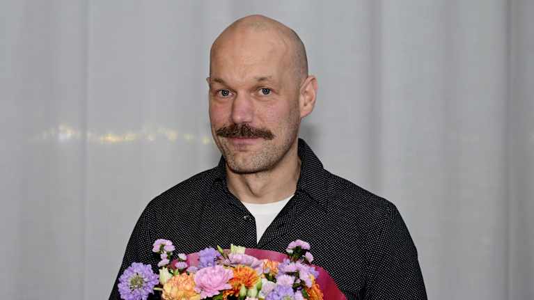 Aleksis Salusjärvi  kukkakimppu kädessään.