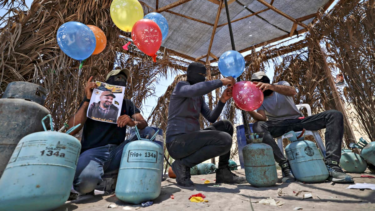 Jihad-liikkeen kannattajat valmistelevat tuhopolttoilmapalloja lähellä Gazaa 15. kesäkuuta 2021.
