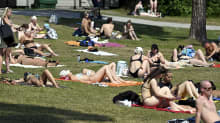 People sunbathing on the grass in Vantaa on 15 June 2023.